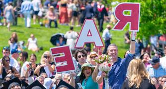 Image of a family supporting their student with signs at commencement.